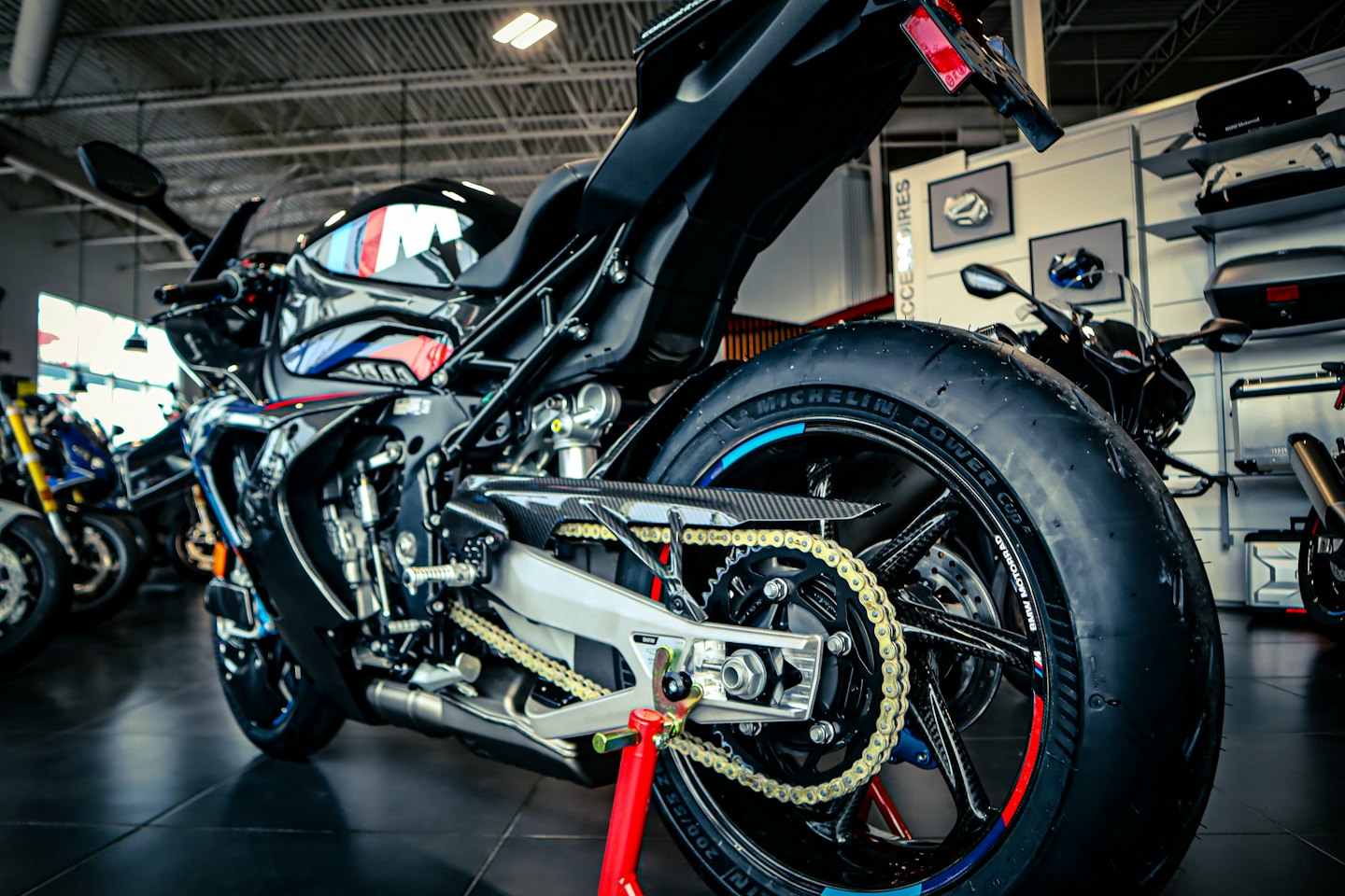 Zwarte sportmotor op een rode standaard in een showroom.