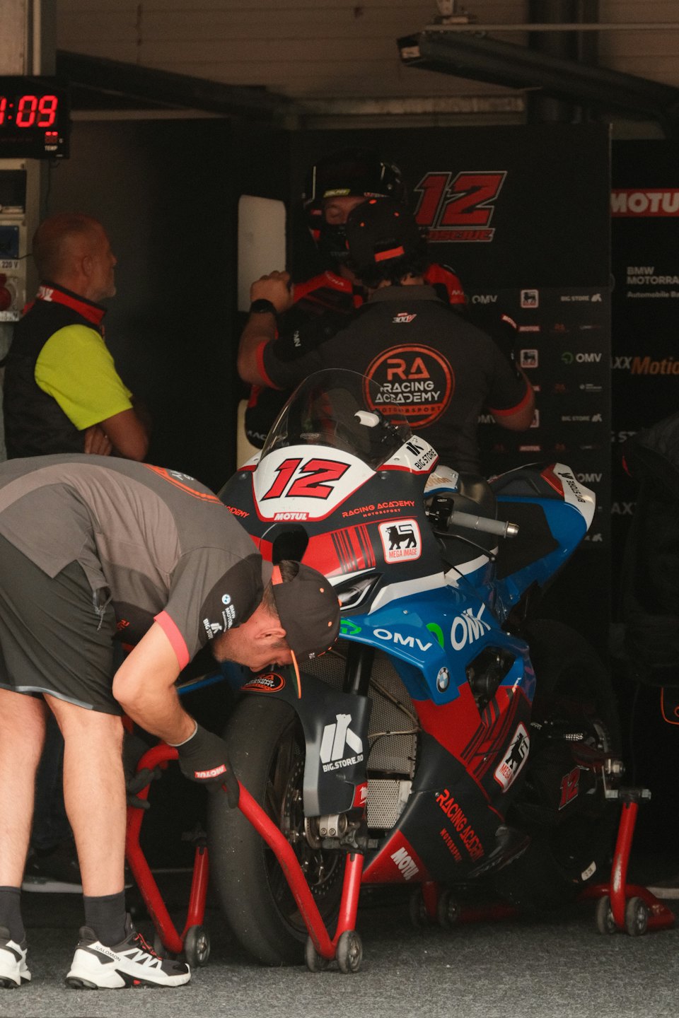 Monteur repareert het wiel van een race-motor in een garage.