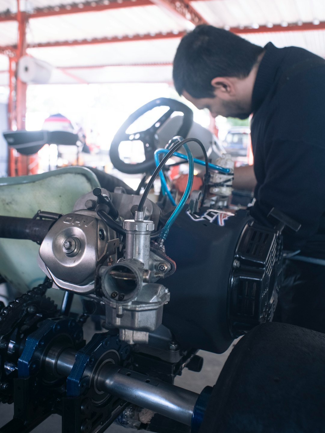 Monteur die aan een kartmotor werkt in een werkplaats.