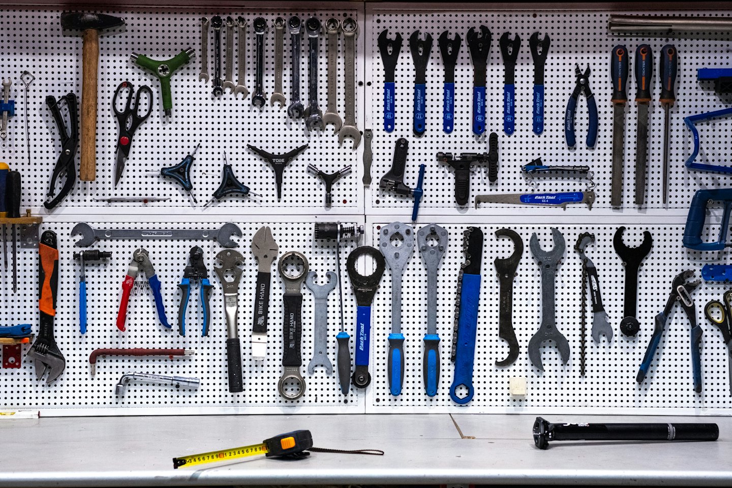 Een pegboard toont een georganiseerde verzameling fietsonderhoudsgereedschap.