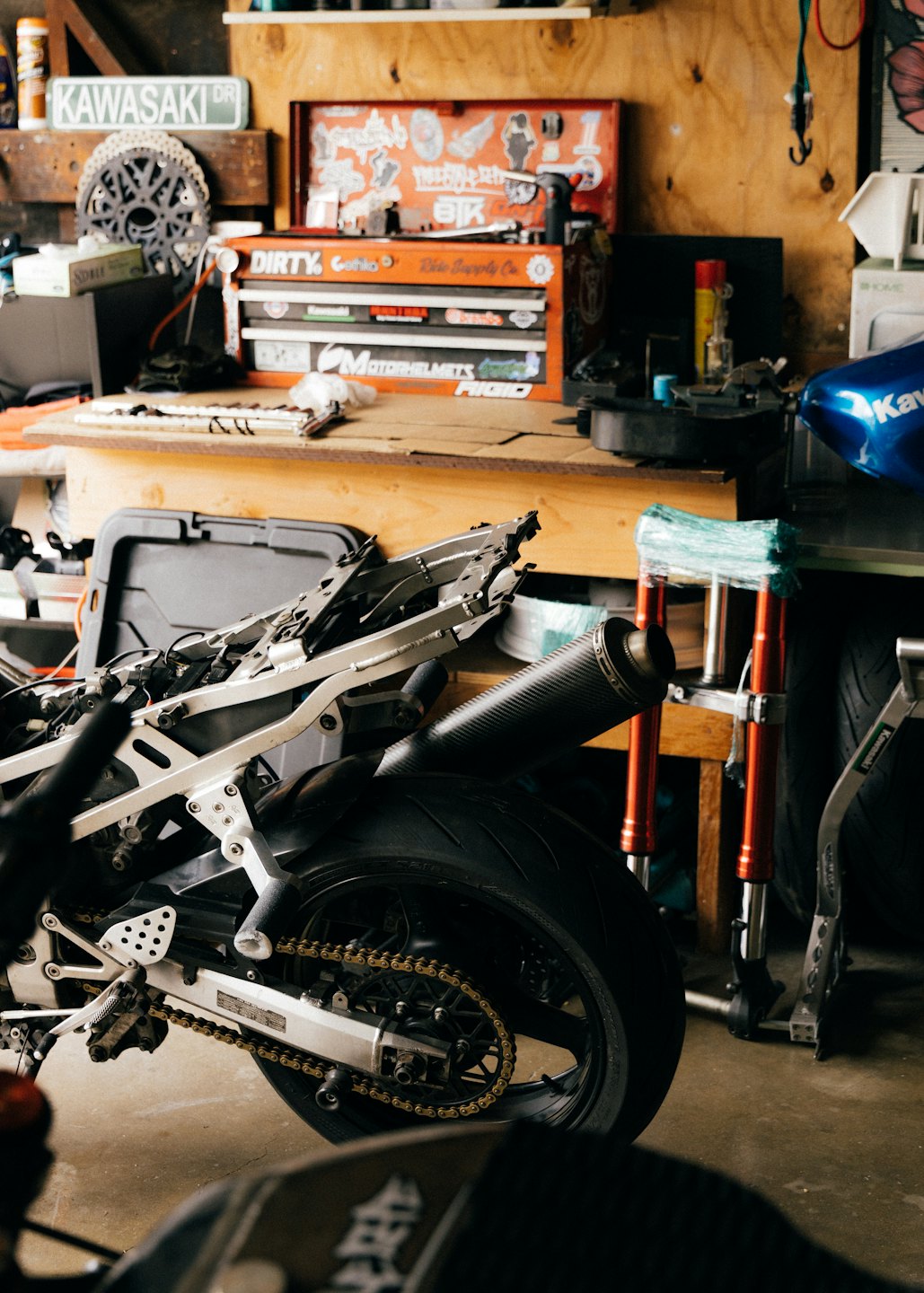 Motorframe en achterwiel in een garage.